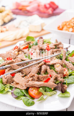 Im asiatischen Stil frischer Salat mit gegrilltem Rindfleisch, Lämmer, Salat, Tomaten und Sesam Stockfoto