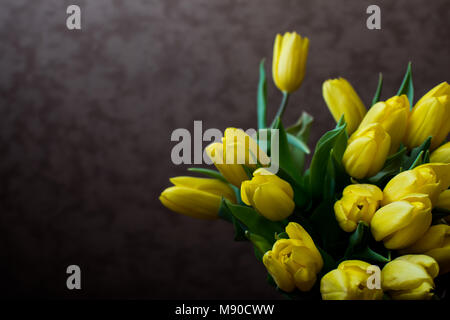 Gelbe Tulpen auf dem schwarzen Hintergrund. Flach, Ansicht von oben. Valentines Hintergrund. Horizontale, Breitbildformat, getönt Stockfoto