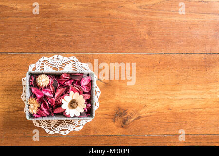 Einen kleinen Korb mit getrockneten Blumen auf einem Holztisch Stockfoto