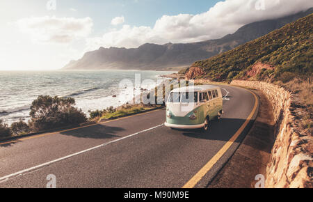 Mini Van auf der Küstenstraße. Gruppe von Freunden unterwegs von einem van auf der Autobahn entlang des Meeres. Stockfoto