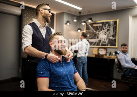 Portrait des jungen Mannes zu Friseur Haare schneiden sitzen warten Stockfoto