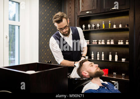 Porträt der jungen Friseur Haar mit Handtuch abwischen Kunde Stockfoto