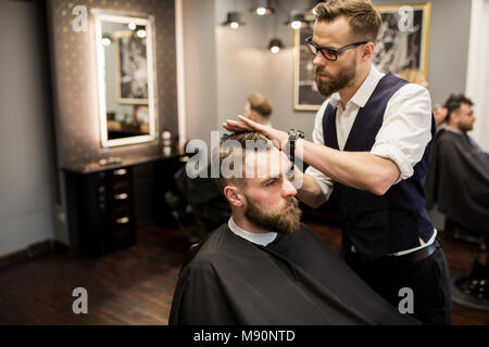 Portrait der fokussierten Friseur arbeiten an Kunden Haar Stockfoto