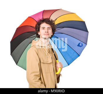 Junger Mann im regenmantel tragen Posiert mit Regenschirm Stockfoto