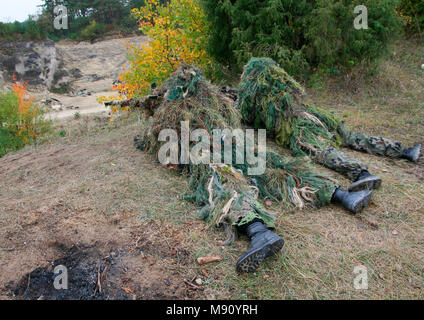 Zwei camouflage Jäger oder Soldaten versteckt im Gebüsch in der Tarnung Herbst Hintergrund. Sniper mit Gewehr. Stockfoto