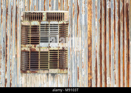 Rusty corregated Metall Wand mit Fenster aussortiert. Stockfoto