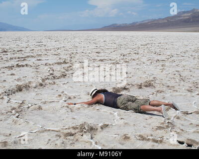 Dehydriert Kerl liegt mit dem Gesicht nach unten auf die salzwiesen von Badwater Basin im Death Valley NP. - Nevada, USA Stockfoto