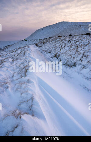 Tiefe Schneeverwehungen neben dem Reitweg in South Head, Hayfield im Peak District, Derbyshire, England. Stockfoto