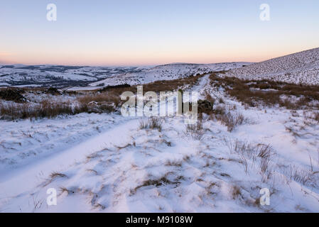 Tiefe Schneeverwehungen neben dem Reitweg in South Head, Hayfield im Peak District, Derbyshire, England. Stockfoto