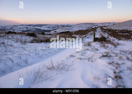 Tiefe Schneeverwehungen neben dem Reitweg in South Head, Hayfield im Peak District, Derbyshire, England. Stockfoto