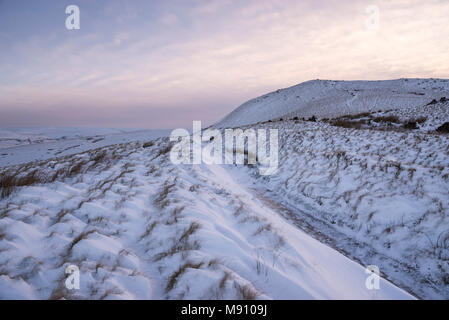 Tiefe Schneeverwehungen neben dem Reitweg in South Head, Hayfield im Peak District, Derbyshire, England. Stockfoto