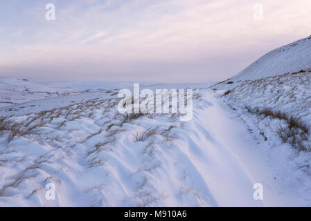 Tiefe Schneeverwehungen neben dem Reitweg in South Head, Hayfield im Peak District, Derbyshire, England. Stockfoto