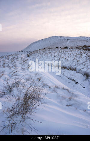 Tiefe Schneeverwehungen neben dem Reitweg in South Head, Hayfield im Peak District, Derbyshire, England. Stockfoto