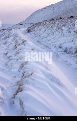 Tiefe Schneeverwehungen neben dem Reitweg in South Head, Hayfield im Peak District, Derbyshire, England. Stockfoto