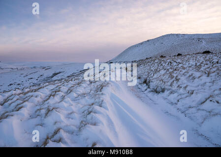 Tiefe Schneeverwehungen neben dem Reitweg in South Head, Hayfield im Peak District, Derbyshire, England. Stockfoto