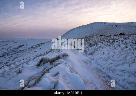 Tiefe Schneeverwehungen neben dem Reitweg in South Head, Hayfield im Peak District, Derbyshire, England. Stockfoto