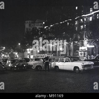 1960, historische, abends Zeit und Französischen Motorwagen der Ära geparkt auf einer gepflasterten Straße in der Nähe der berühmten Avenue des Champs-Elysées, Paris, Frankreich. Stockfoto