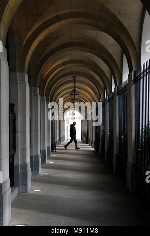 Ein Mann unter den Arkaden im Savoy Place, London. Stockfoto