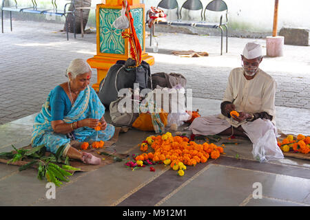 Alte Paar, Girlanden mit Ringelblume Blumen auf Shri Vitthal Rakhumai Tempel, Pimpri, Pune Stockfoto