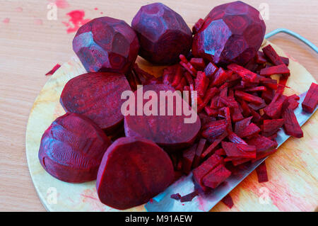 Rote Bete in Scheiben geschnittene Streifen, Zuckerrüben gehackt Hälften, rohe rote Beete zum Kochen Stockfoto