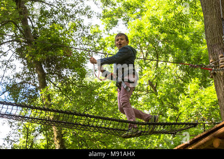 Der 11-jährige Junge auf einem Hochseilgarten. Frankreich. Stockfoto