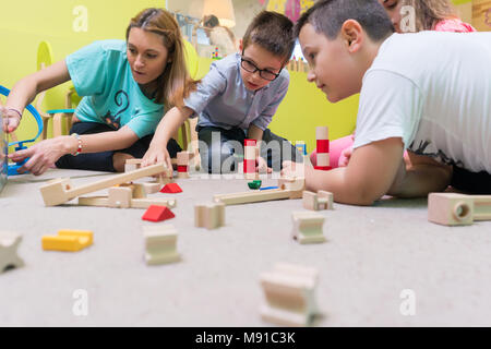 Weibliche Erzieher, die Kindern einen Zug Schaltung zu bauen Stockfoto