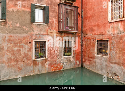 Eine versteckte Ecke des alten traditionellen venezianischen Gebäude mit roten Ziegelsteinen und Beton auf einem Kanal in Venedig, Italien. Typische italienische Architektur Stockfoto