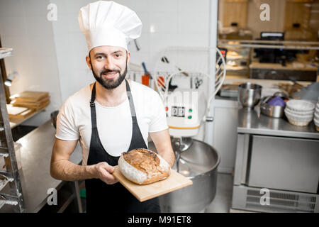 Bäcker mit Brot in der Bäckerei Stockfoto