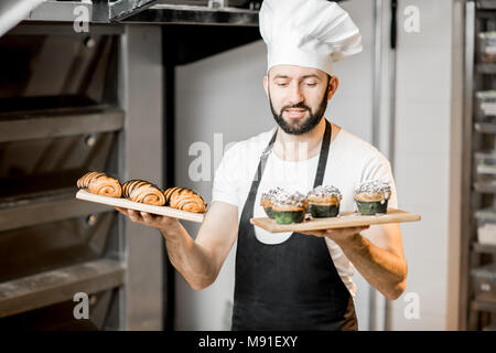 Konditor mit süßem Gebäck in der Fertigung Stockfoto