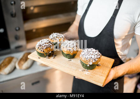 Baker Holding maffins in der Bäckerei Stockfoto