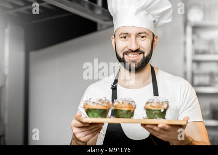 Konditor mit süßem Gebäck in der Fertigung Stockfoto