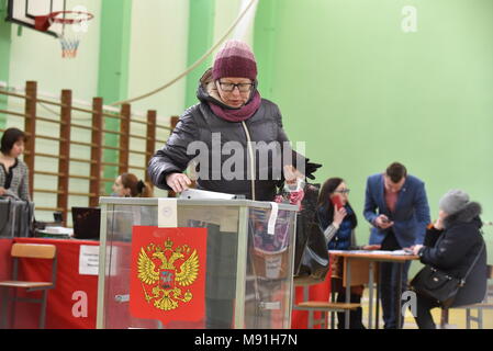 St. Petersburg, Russland - 18. MÄRZ 2018: eine Frau wirft ihren Stimmzettel während der russischen Präsidentschaftswahlen 2018 im Wahllokal. Stockfoto