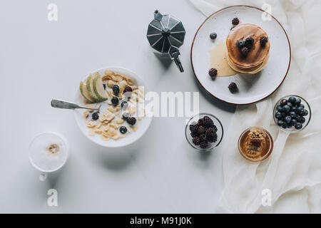 Blick von oben auf die frische, gesunde leckeres Frühstück mit Kaffee auf Grau Stockfoto