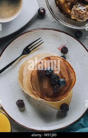 Blick von oben auf die Süße hausgemachte Pfannkuchen mit Beeren und Honig Stockfoto