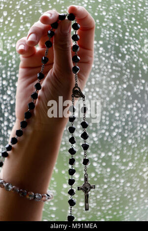 Katholische betende Frau mit Rosenkranz. Close-up. Stockfoto