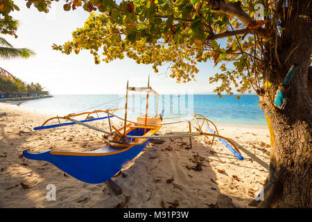 Hintergrundbeleuchtung traditionelle philippinische banca Boot am Strand bei Sonnenuntergang, Palawan, Philippinen Stockfoto