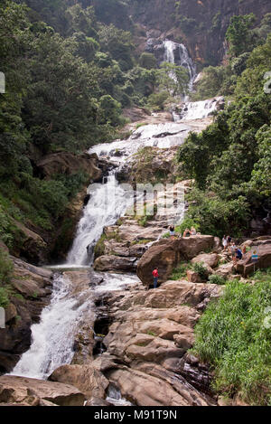 Die Ravana fällt in der Nähe von Ella in Sri Lanka mit Touristen klettern über die Felsen. Stockfoto