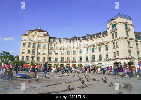 München Deutschland - September 8, 2017; Leute und Tauben genießen Sie sonnige Tag von berühmten Osram Schild am Münchner Karlsplatz (Stachus) an einem geschäftigen Tag Stockfoto