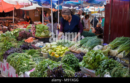 Eine ältere Frau verkauft eine Vielzahl von frischem Gemüse an der Dezerters" Basar Open-Air-Markt, Tiflis, Georgien Stockfoto