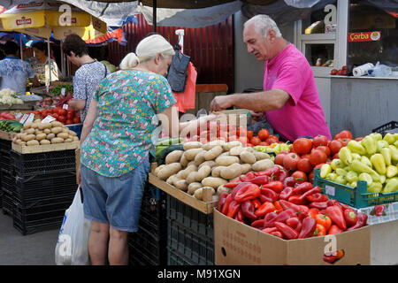 Eine Frau kauft frisches Gemüse von einem Verkäufer am Dezerters" Basar Open-Air-Markt, Tiflis, Georgien Stockfoto