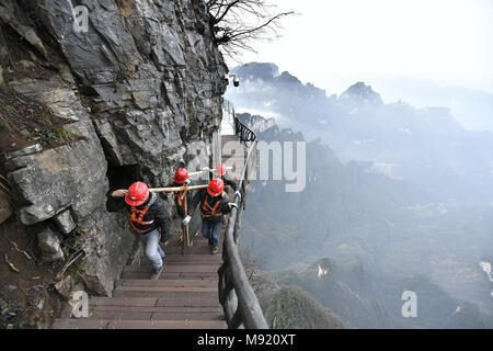 Zhangjiajie, Hunan Provinz Chinas. 21 Mär, 2018. Die Arbeitnehmer tragen eine ersetzt Glasplatte an Tianmenshan Scenic Area in Granby, der Central China Hunan Provinz, 21. März 2018. Austausch des Glases Bürgersteig auf der Westseite in Tianmenshan ist in Bearbeitung, die voraussichtlich in zwei Tagen abzuschließen. Credit: Shao Ying/Xinhua/Alamy leben Nachrichten Stockfoto