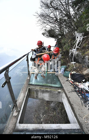 Zhangjiajie, Hunan Provinz Chinas. 21 Mär, 2018. Die Arbeitnehmer tragen Glasplatten für den Austausch der Glas Fahrbahn in Tianmenshan Scenic Area in Granby, der Central China Hunan Provinz, 21. März 2018. Austausch des Glases Bürgersteig auf der Westseite in Tianmenshan ist in Bearbeitung, die voraussichtlich in zwei Tagen abzuschließen. Credit: Shao Ying/Xinhua/Alamy leben Nachrichten Stockfoto