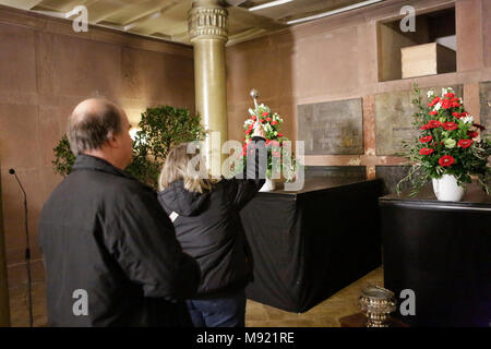 Mainz, Deutschland. 21. März 2018. Eine Frau besprüht heiliges Wasser am offenen Grab von Karl Kardinal Lehmann. Das Grab von Karl Kardinal Lehmann in der Bischöflichen Gruft der Mainzer Dom war für die Öffentlichkeit zugänglich, nachdem die Exequien, so dass die Menschen ihre letzten Respekt am Grab bezahlen konnte. Stockfoto