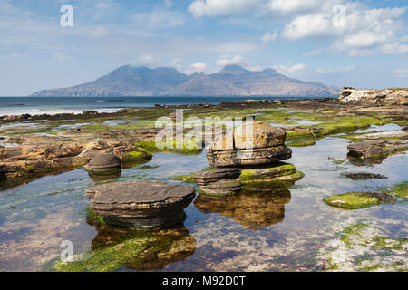 Sandstein Konkretionen in der Bucht von laig auf der Isle of Eigg, Inneren Hebriden in Schottland. Die Berge in der Ferne sind auf der Insel Rum. Stockfoto