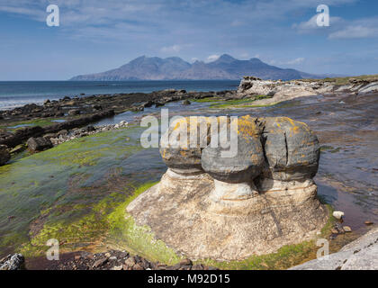 Sandstein Konkretionen in der Bucht von laig auf der Isle of Eigg, Inneren Hebriden in Schottland. Die Berge in der Ferne sind auf der Insel Rum. Stockfoto