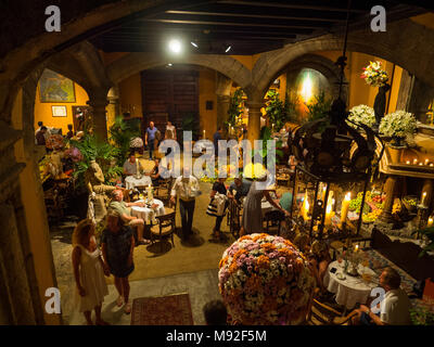 Traditionelle Café Bar auf Mallorca mit Kellner hinter Kunden. Blumen, Kerzen und Früchten dekorieren der Tische und Innenhof Stockfoto