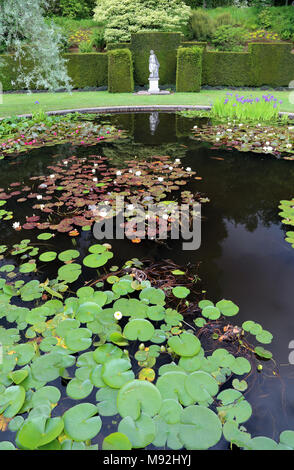 Eine Statue im Pool Garten von Knightshayes Court, Tiverton, Devon, Großbritannien. Das Gebäude und die Gärten des National Trust. Stockfoto