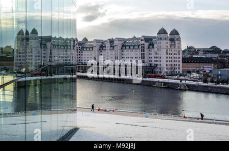 Oslo, Norwegen, 16. März 2018: Havnelageret, die alten kommerziellen Gebäude in Langkaia 1, der in den Fenstern der Osloer Oper in Bjørvika wider. Stockfoto