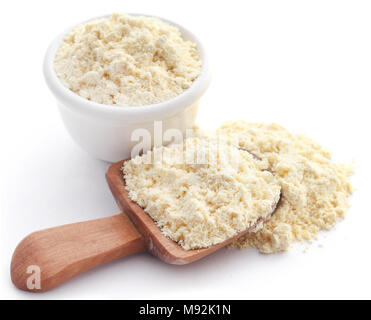 Gramm Mehl in Schüssel und hölzerne Schaufel auf weißem Hintergrund Stockfoto