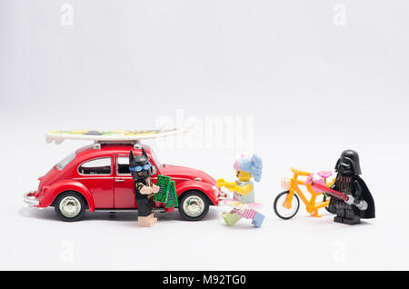 Lego Batman mit Auto und Geld jagen n-pop Mädchen, mit Darth Vader zu beobachten und hält eine Blume. Stockfoto